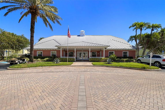 Front view of a single-story building with a metal roof and an American flag in front.