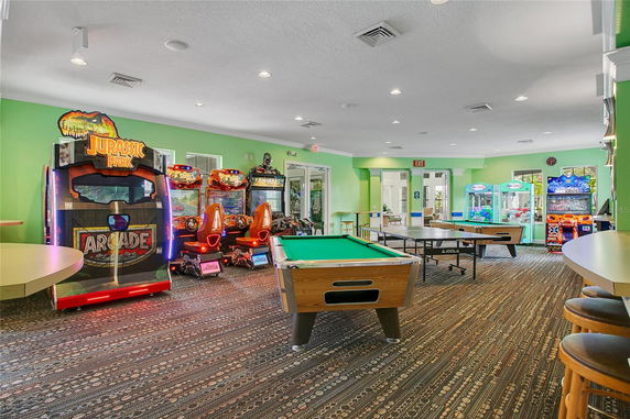 Indoor recreation area with arcade games and a pool table.