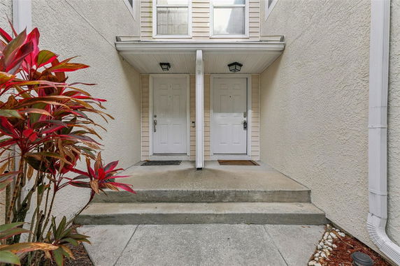 Entryway with two white doors and steps leading up.