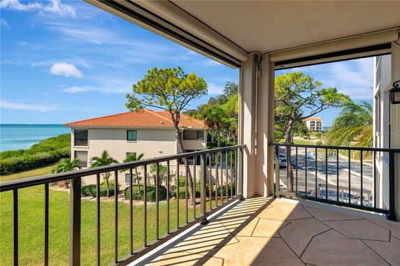 Balcony view overlooking the sea and surrounding buildings.