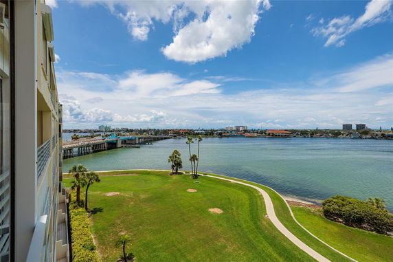 Panoramic view of a waterfront landscape with a building on the left and a bridge over the water.