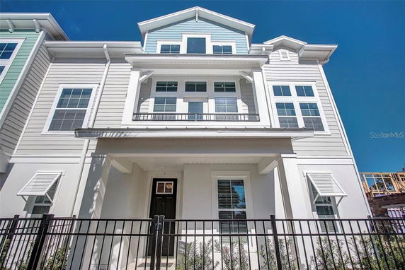 Front view of a multi-story house with a modern design and large windows.