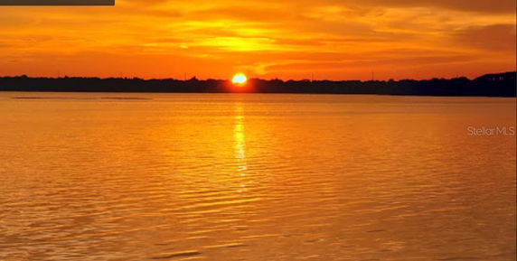 A panoramic view of a sunset over a body of water with an orange sky.