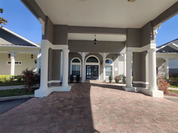 Front view of a building with a covered entrance and decorative columns.