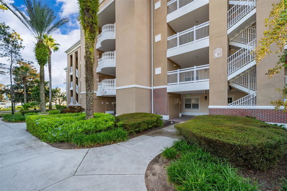 Front view of a multi-story apartment building with balconies and an external staircase.