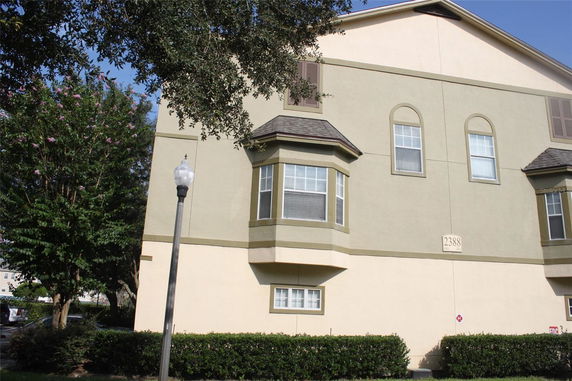 Front view of a multi-story building with bay windows.