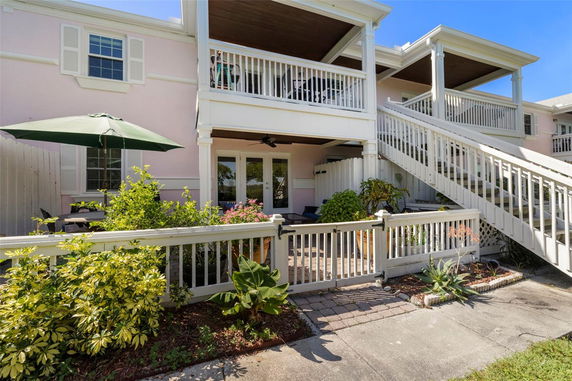 Front view of a two-story house with a balcony and patio.