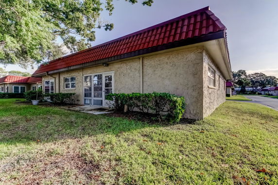 Front view of a single-story building with red roof tiles and stucco walls.