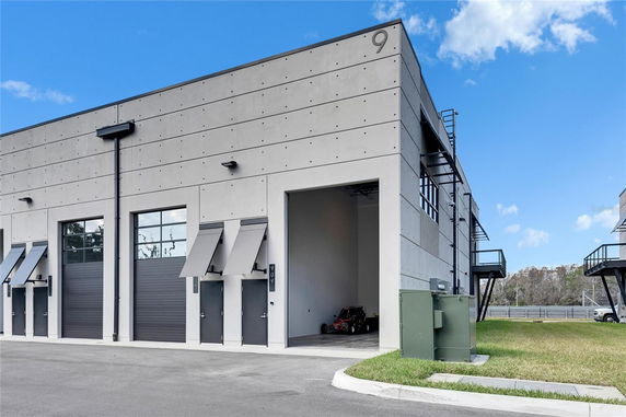 Front view of a modern industrial style building with large garage doors.