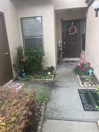Front view of a house entrance with a doorway, windows, and garden decorations.