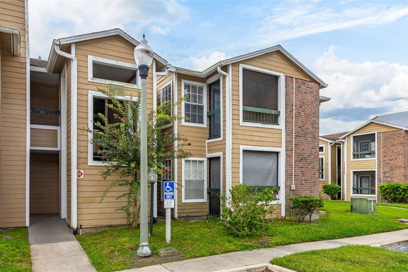 Front view of a multi-story apartment building with brick and wood siding.