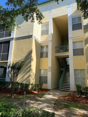 Three-story apartment building with stairs and multiple windows.