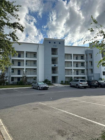 Front view of a multi-story apartment building with balconies.