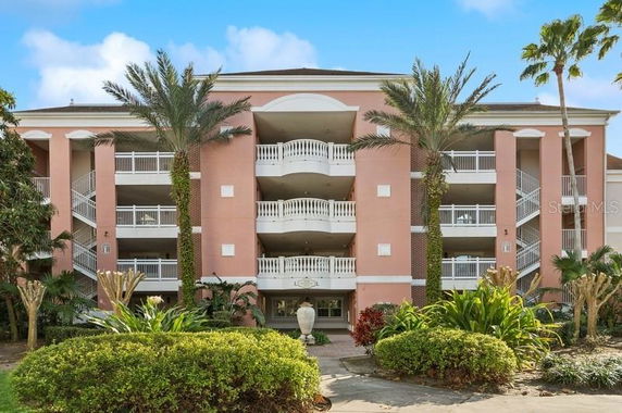 Front view of a multi-story building with balconies and a pink facade.