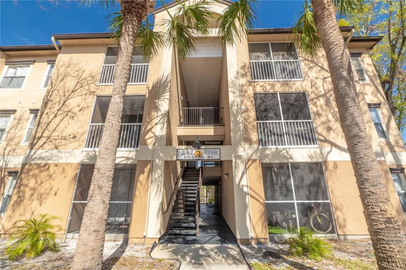 Front view of a multi-story apartment building with outdoor stairs.