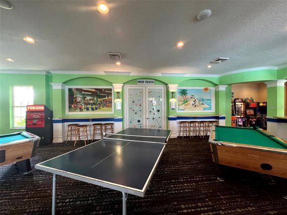 Indoor recreation area with a table tennis table and pool tables.