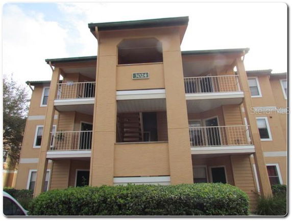 Front view of a three-story apartment building with balconies.