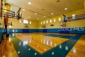 Indoor basketball court with wooden flooring and multiple basketball hoops.