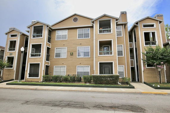 Front view of a three-story apartment building with balconies.