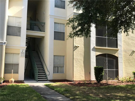 Front view of a multi-story apartment building with exterior staircases.