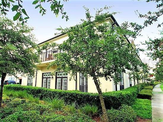 Front view of a two-story house with a balcony and a well-maintained garden.