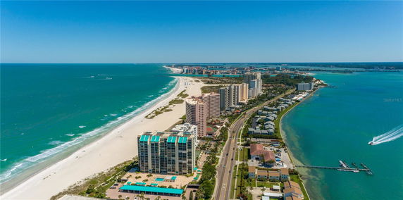 Panoramic view of beachfront buildings along a coastline with sandy beach and ocean.