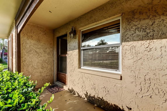 Front view of a house with a textured exterior wall and a window.