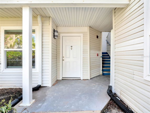 Front view of a house entrance with a white door and siding.