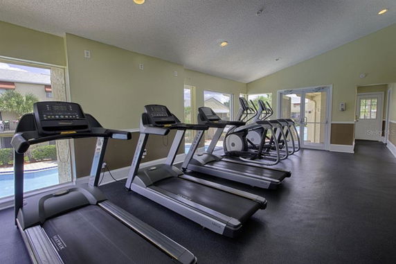 Indoor gym area with multiple treadmills and exercise machines.