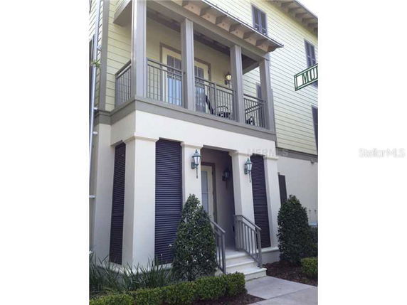 Front view of a two-story house with a balcony and entrance steps.