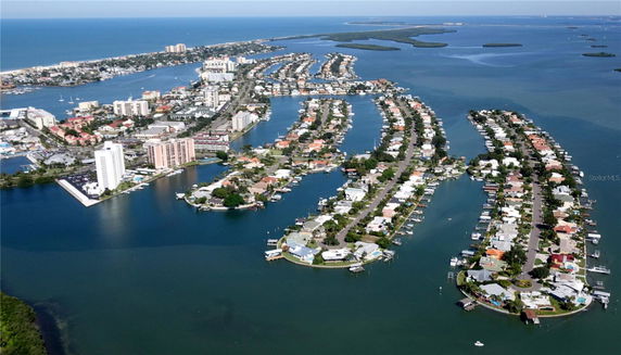 Aerial view of a coastal city with waterways and island-like neighborhoods.
