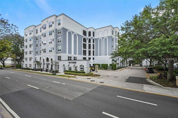 Front view of a multi-story residential building with white and gray exterior.