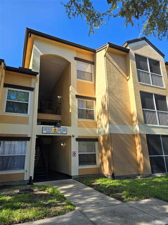 Front view of a multi-story apartment building with an archway entrance.