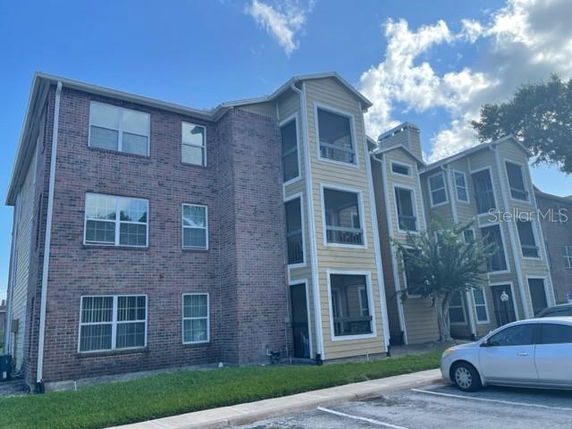 Front view of a multi-story apartment building with brick and siding exterior.