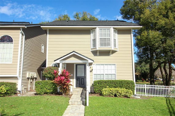 Front view of a two-story house with siding and a bay window.