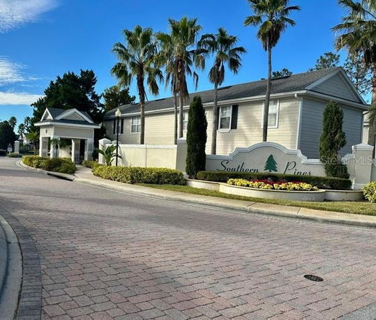 Front view of a two-story building with palm trees and a sign reading 'Southern Pines.'