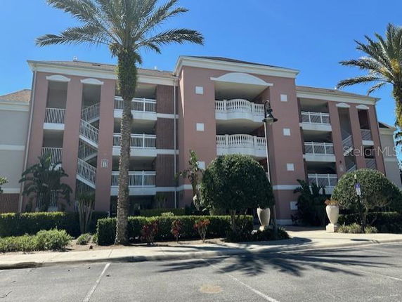 Front view of a multi-story building with balconies and staircase.