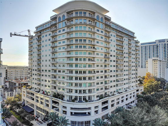 Front view of a tall apartment building with multiple balconies.