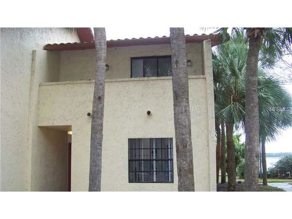 Front view of a two-story house with a balcony and beige exterior.