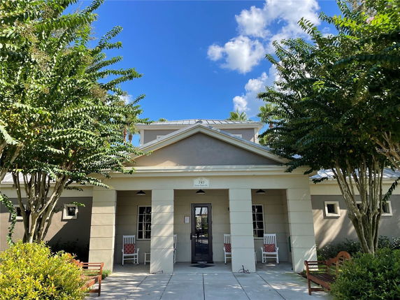 Front view of a building with columns and a gable roof entrance