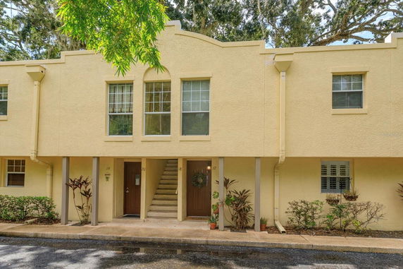 Front view of a townhouse with two floors and yellow exterior walls.