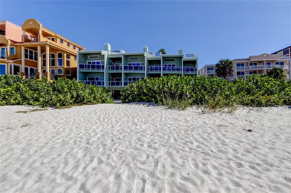 Front view of multi-story beachfront buildings.