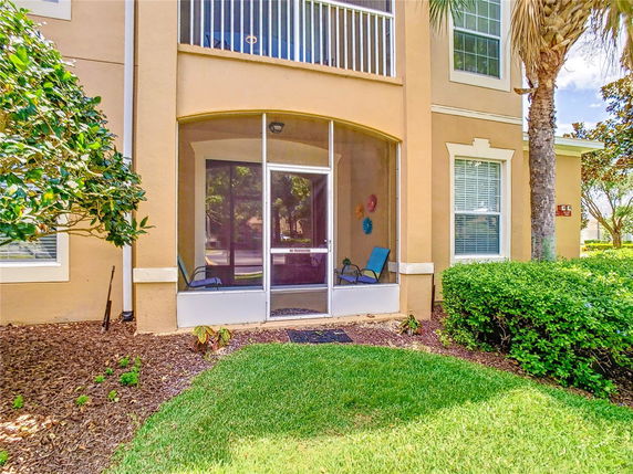 Front view of a two-story house with a screened porch area on the ground floor and a balcony above.