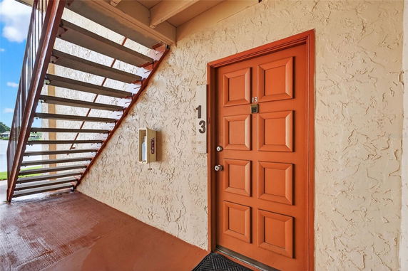 Close-up view of an orange door and staircase exterior.