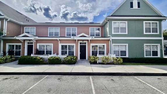 Front view of a two-story residential building with multiple entrances and a mixed-color facade.