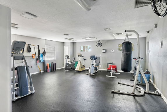 Interior view of a gym area with exercise equipment including treadmills and a punching bag.