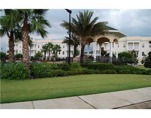 Front view of a large building with arches and palm trees.