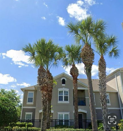 Front view of a multi-story residential building with a pitched roof.