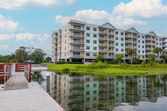 Front view of a multi-story apartment building near a body of water.