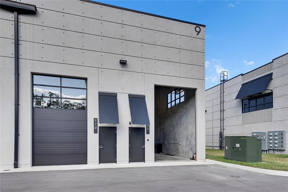 Front view of an industrial building with large doors and a covered entrance.